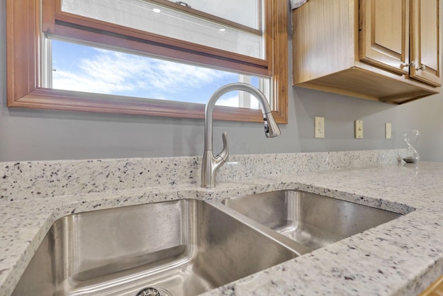 interior details featuring light stone counters and sink