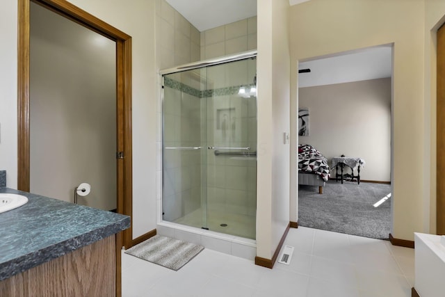 bathroom featuring tile patterned floors, a shower with door, and vanity