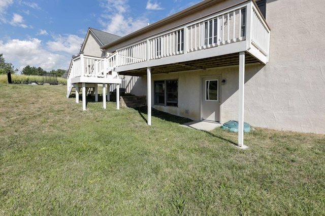 back of house with a lawn and a deck