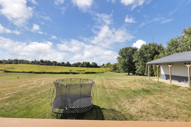 view of yard featuring a rural view and a trampoline