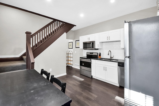 kitchen featuring white cabinetry, sink, stainless steel appliances, tasteful backsplash, and dark hardwood / wood-style flooring