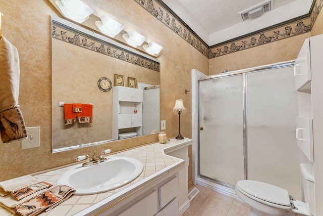 bathroom featuring a shower with door, vanity, a textured ceiling, and tile patterned flooring