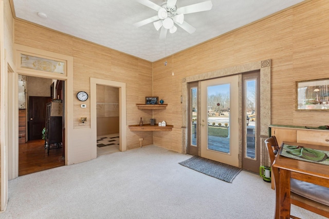 entryway with ceiling fan and light colored carpet