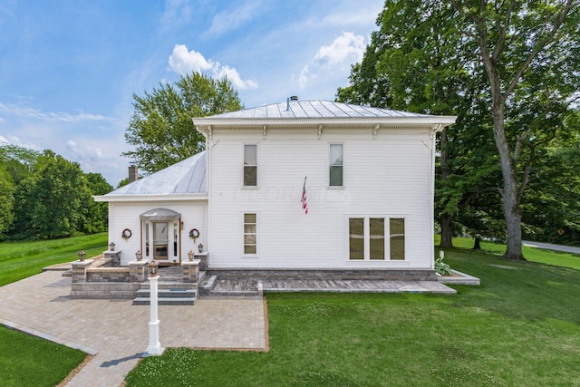 rear view of house featuring a patio area and a yard