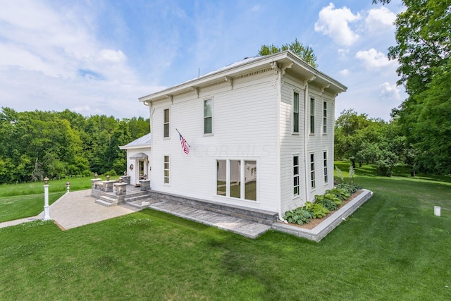 back of house featuring a patio area and a lawn