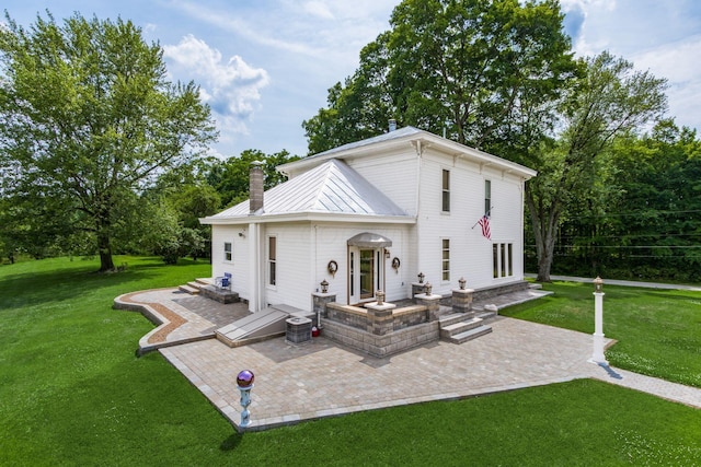 rear view of house with a lawn, cooling unit, and a patio