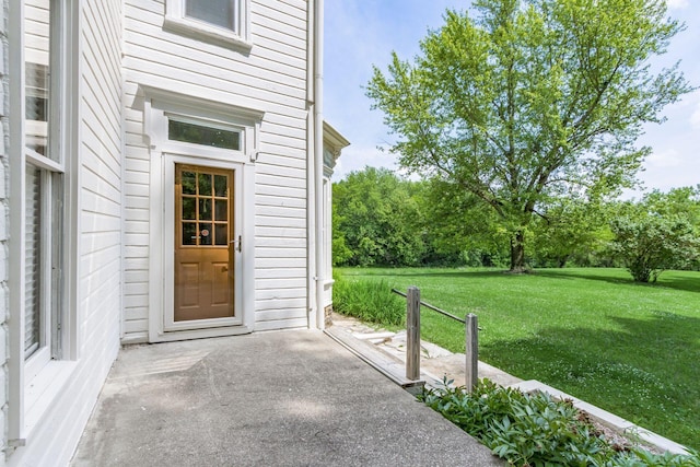 entrance to property featuring a lawn