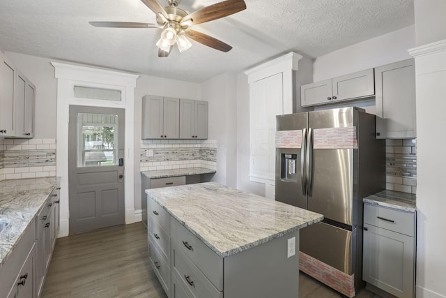 kitchen featuring gray cabinetry, decorative backsplash, stainless steel fridge, and dark hardwood / wood-style floors