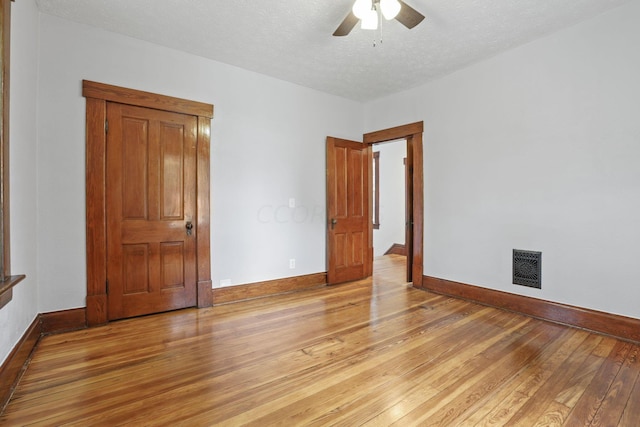 unfurnished bedroom with ceiling fan, light wood-type flooring, and a textured ceiling