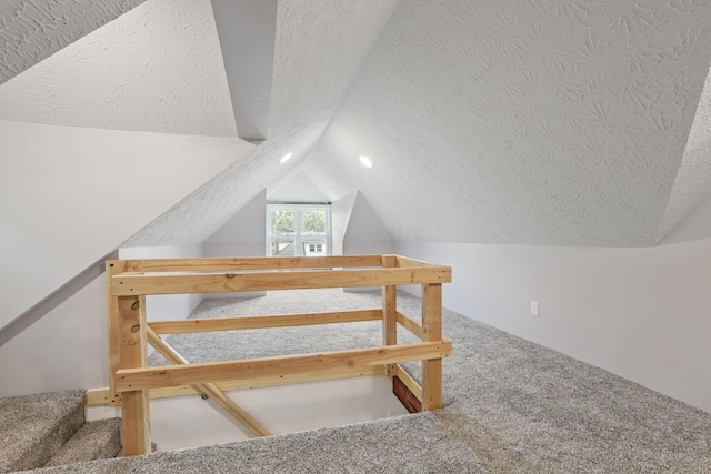 bonus room with carpet, a textured ceiling, and vaulted ceiling