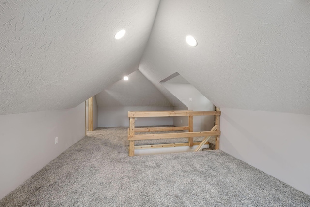 bonus room featuring light colored carpet, a textured ceiling, and vaulted ceiling