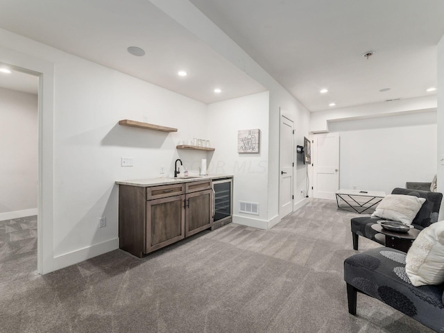 bar featuring carpet flooring, dark brown cabinetry, sink, and wine cooler