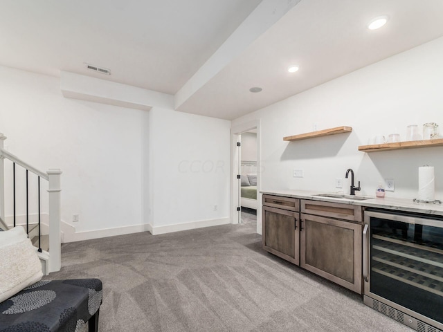 bar featuring light colored carpet, wine cooler, and sink