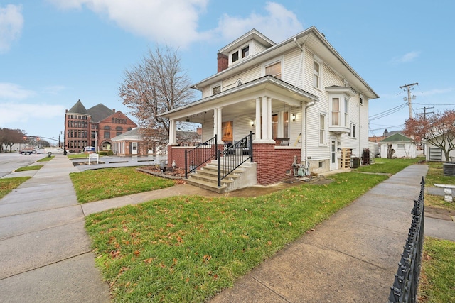 view of front of home with a porch and a front lawn