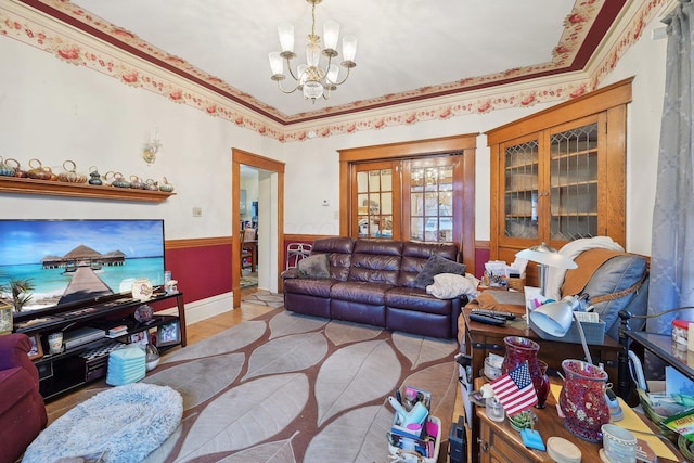 living room featuring a notable chandelier, light hardwood / wood-style floors, and ornamental molding