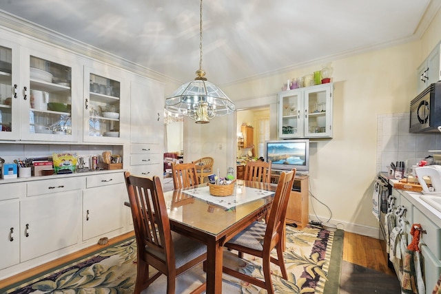 dining space with a chandelier, dark hardwood / wood-style floors, and ornamental molding