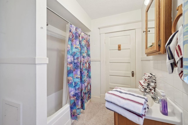 bathroom with a textured ceiling and shower / bath combo