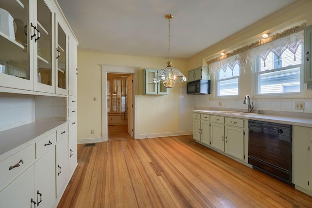 kitchen with light wood-style flooring, a sink, black appliances, light countertops, and crown molding