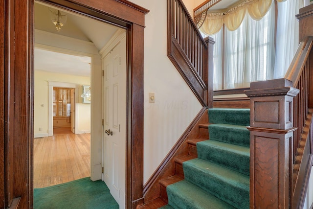 staircase with baseboards and wood finished floors