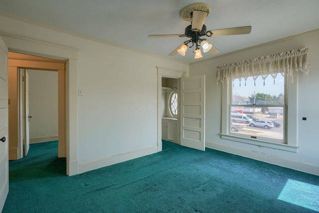 spare room featuring carpet flooring, ceiling fan, crown molding, and baseboards