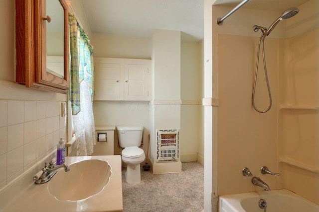 full bath featuring vanity, heating unit, bathtub / shower combination, toilet, and backsplash