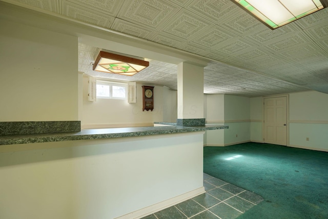 interior space with dark carpet, baseboards, and an ornate ceiling