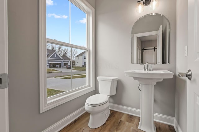 bathroom featuring hardwood / wood-style floors and toilet