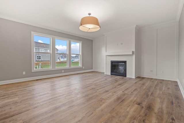 unfurnished living room featuring light wood-type flooring and ornamental molding