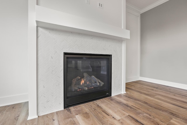 details with a tile fireplace, hardwood / wood-style floors, and ornamental molding