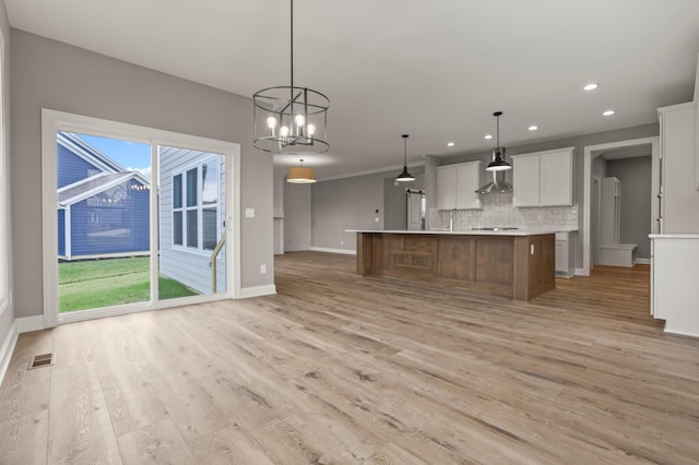 kitchen with a spacious island, decorative light fixtures, tasteful backsplash, a notable chandelier, and white cabinetry