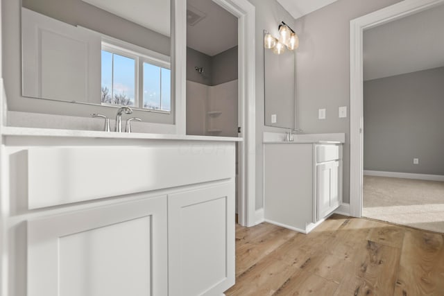 bathroom featuring vanity, wood-type flooring, and walk in shower