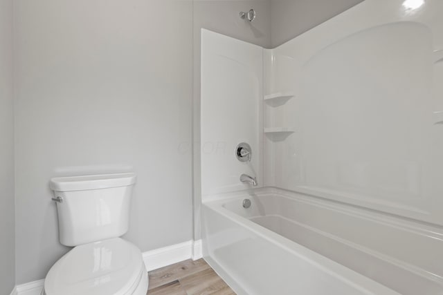 bathroom featuring shower / tub combination, hardwood / wood-style flooring, and toilet