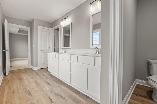 bathroom featuring vanity, toilet, wood-type flooring, and a textured ceiling