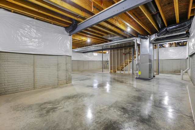 basement with heating unit and brick wall