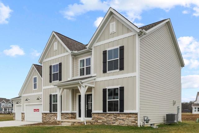 view of front of home with a front lawn, cooling unit, and a garage