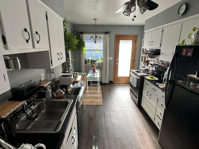 kitchen with black appliances, white cabinets, sink, hanging light fixtures, and dark hardwood / wood-style flooring