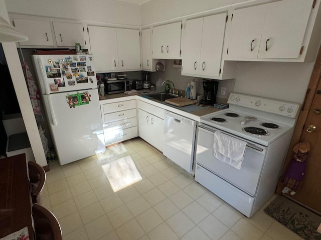 kitchen with white cabinets, white appliances, sink, and light tile patterned floors