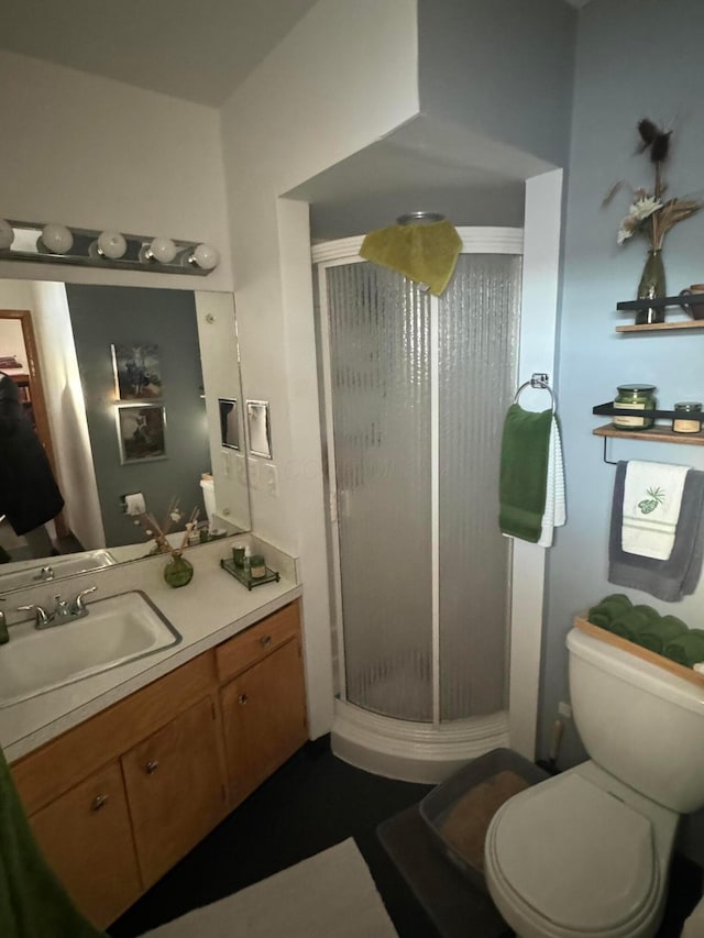 bathroom featuring vanity, toilet, and an enclosed shower