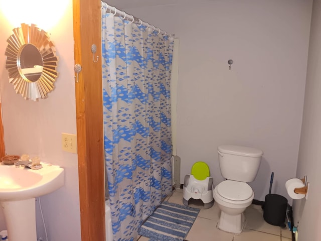 bathroom featuring tile patterned flooring, a shower with shower curtain, and toilet