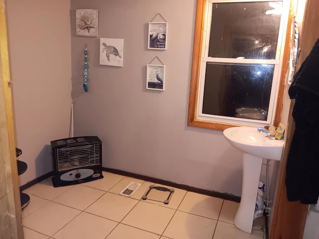 bathroom featuring heating unit and tile patterned floors