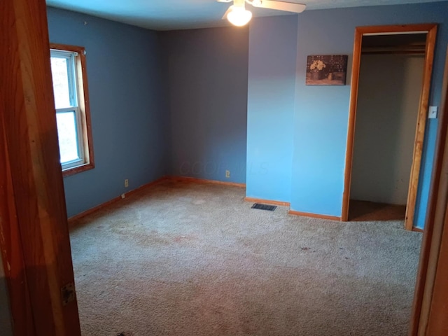 spare room featuring ceiling fan and carpet flooring