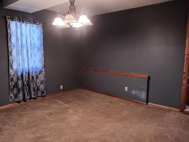 spare room with a chandelier and carpet