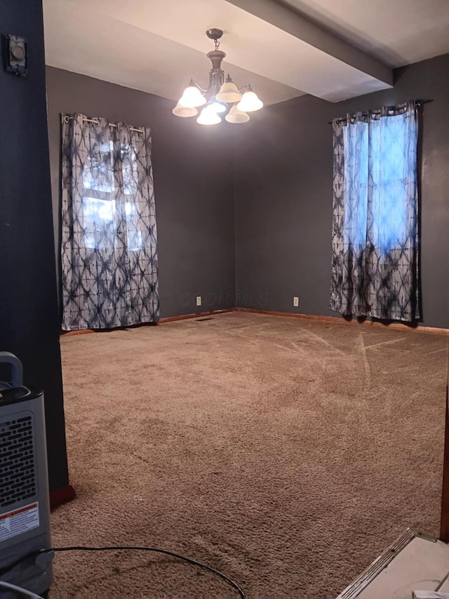 carpeted spare room with heating unit and a notable chandelier