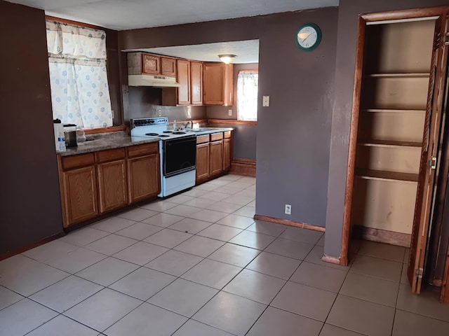 kitchen with sink, light tile patterned floors, and electric stove