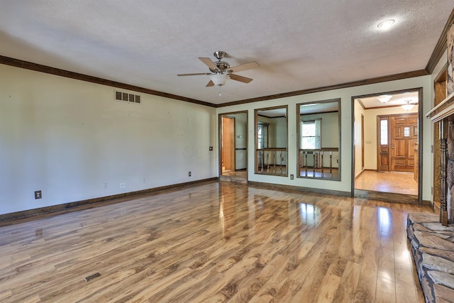 empty room with ceiling fan, light hardwood / wood-style floors, ornamental molding, and a textured ceiling