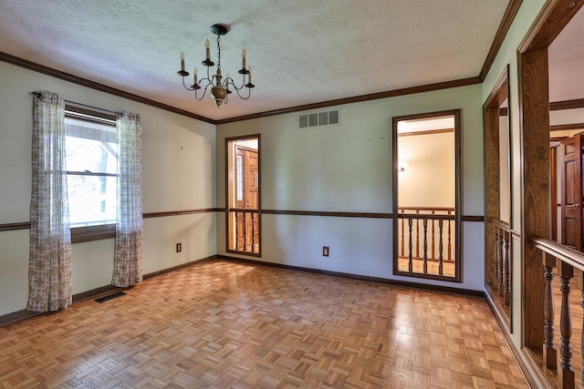 spare room with a chandelier, ornamental molding, a textured ceiling, and light parquet floors