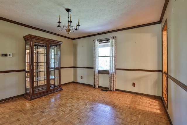 spare room with crown molding, light parquet floors, a textured ceiling, and an inviting chandelier