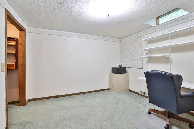 home office with light colored carpet and a textured ceiling