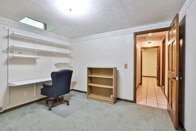 carpeted home office featuring a textured ceiling