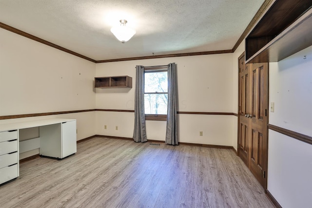 unfurnished office featuring crown molding, light hardwood / wood-style floors, and a textured ceiling